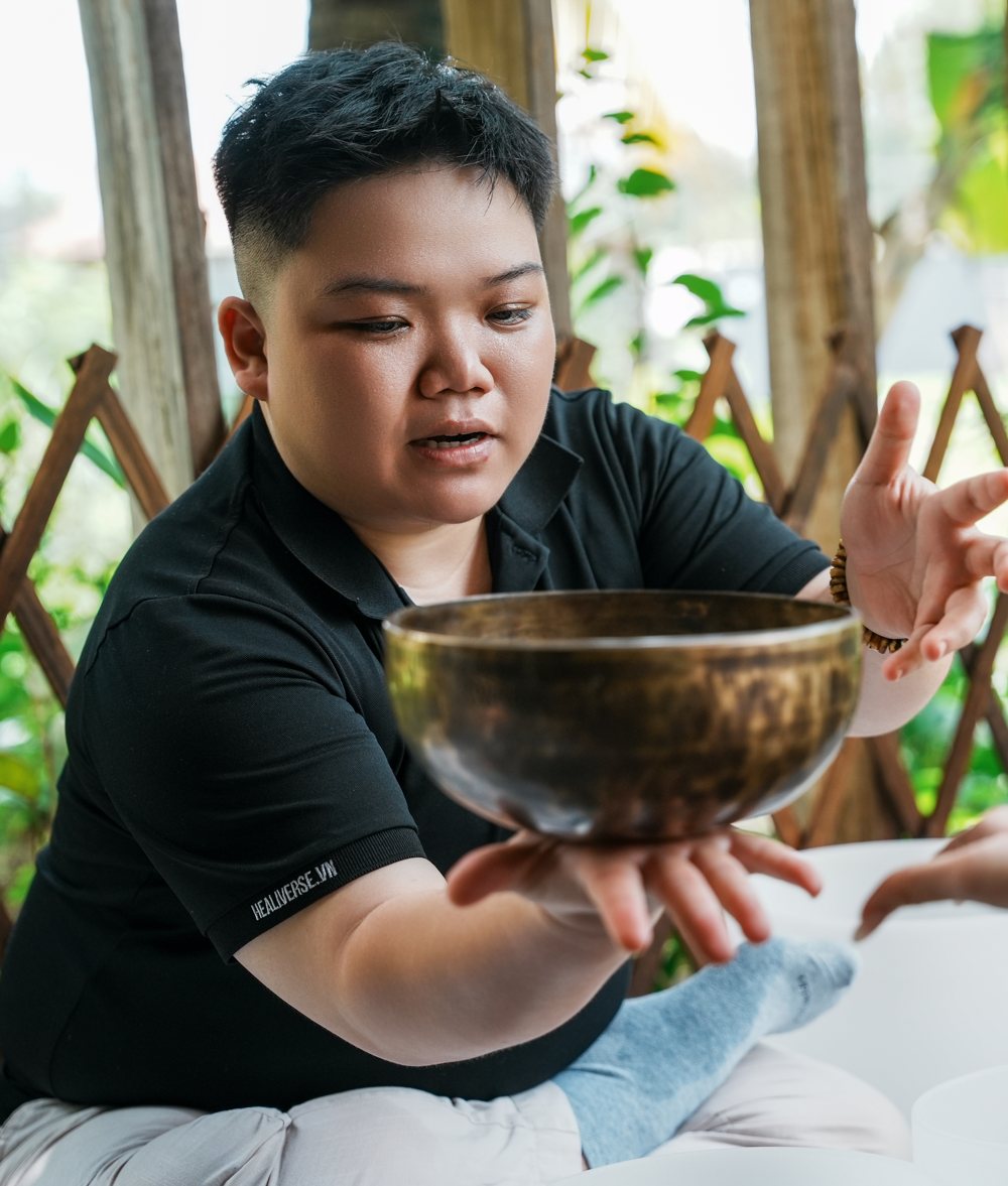 Kennedy guiding a guest with a Himalayan singing bowl